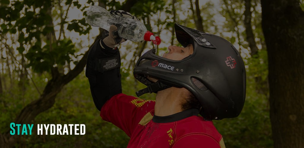 a man wearing his helmet drinking water