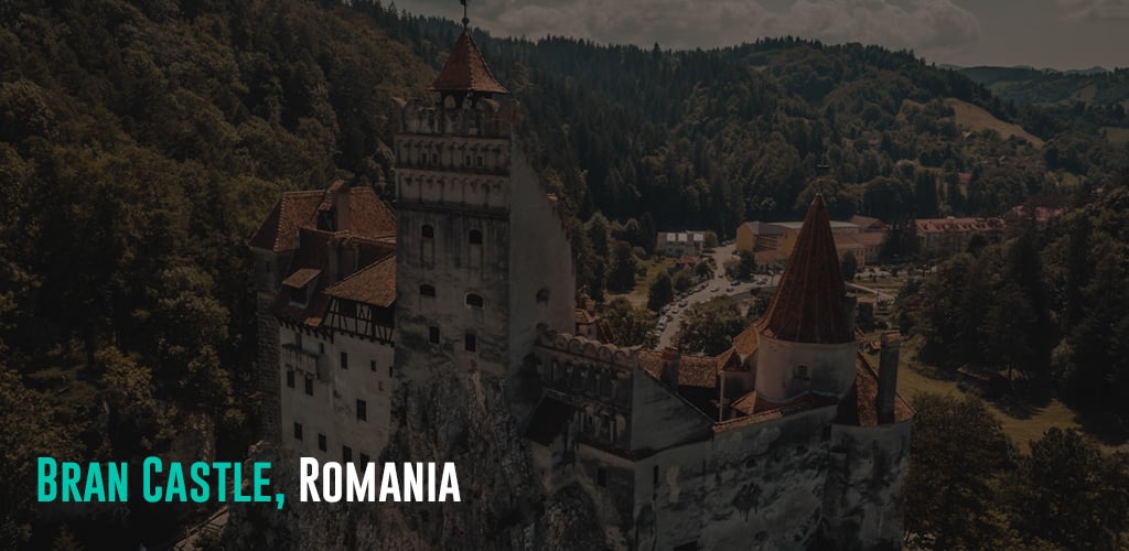 a grey and brown castle in the middle of a forest