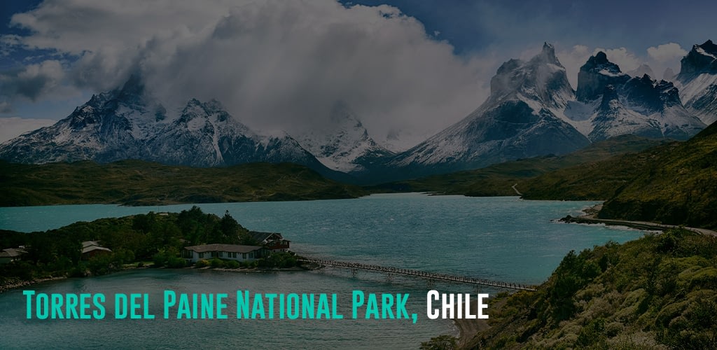 a view of a lake with a port and a view of the mountains covered by clouds
