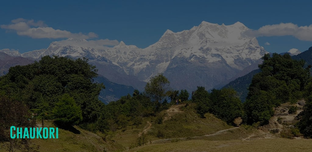 a mountain filled with nature with a view of the majestic Nanda Devi and Panchchuli mountain peaks