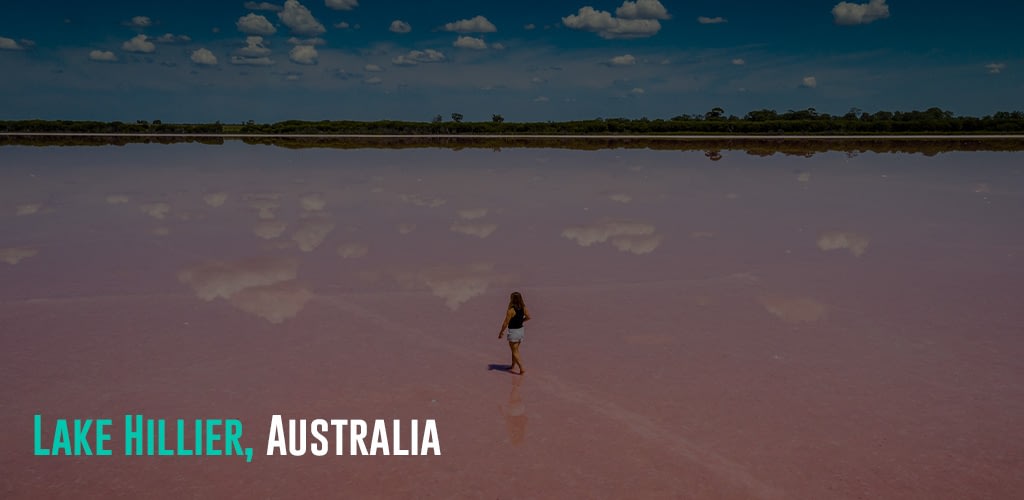 a woman walking on pink colored water on a sunny day