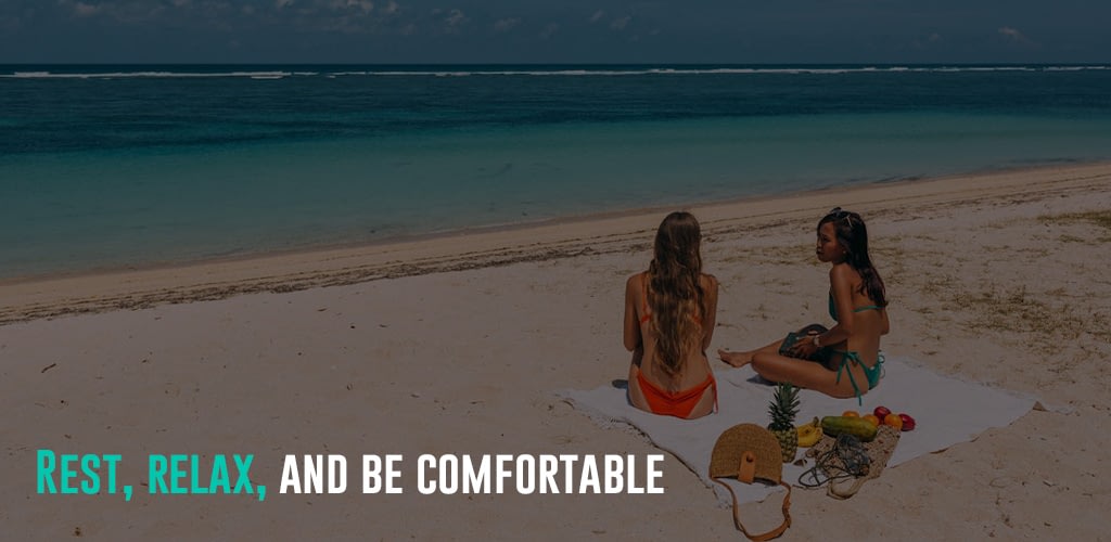 2 ladies talking and sitting at the beach